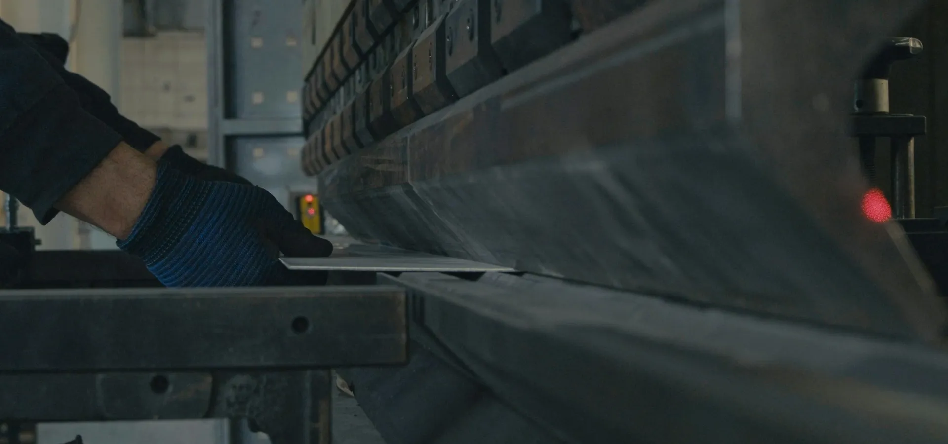 A steel plate being worked on a press brake in a fabrication shop.